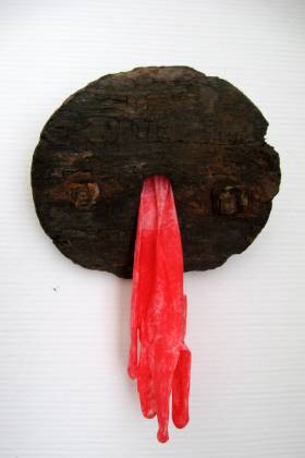 'o. Titel' Eichenholzfindling mit rot eingefärbten Gummihandschuh . Gestaltet von Matzi Müller,  Atelier Donnerkeil auf Kap Arkona.