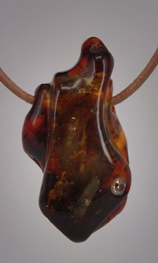 Bernstein - Ahnänger. Geschliffen und polier, mit kleinem Zirkonia. Bernstein - Anhänger.<br />
Geschliffen und poliert, kleinem Zirkonia . Gestaltet von Matzi Müller, im Atelier Donnerkeil.